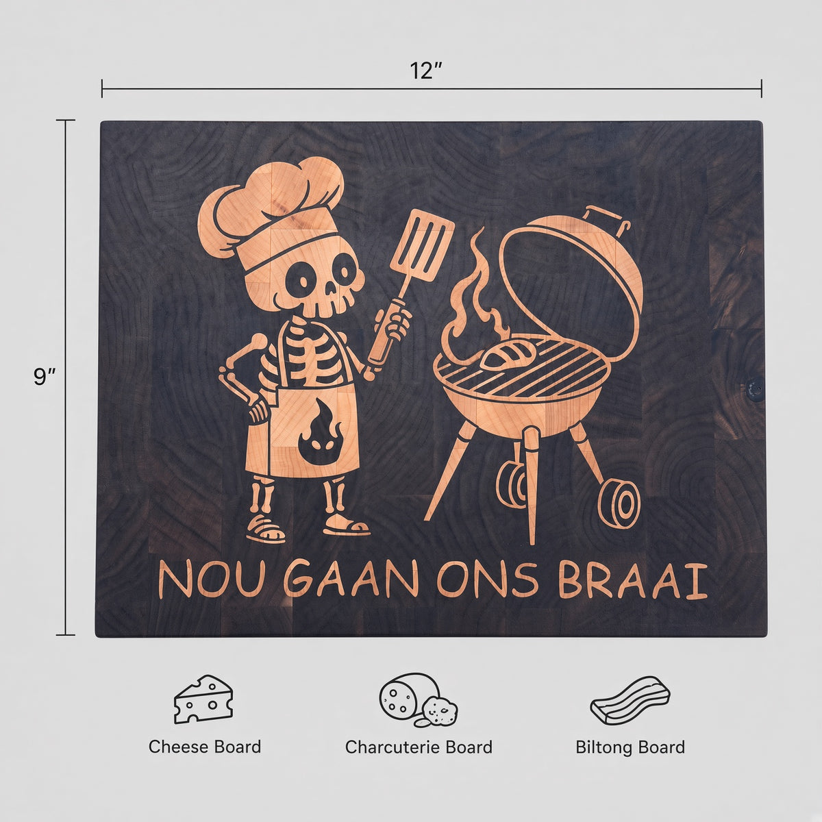 A premium everyday end-grain cutting board with Brass feet.

Materials: Base is walnut wood with a hard maple inlay.

Design: With a carved skeleton chef grilling next to a charcoal grill, with the text 'NOU GAAN ONS BRAAI' below.

Uses:
- Chopping Board
- Cheese or Meat Board
- Charcuterie Board
- Biltong Board

Note: Wood is a natural material, and the received product will have wood color and grain variations compared to this picture.